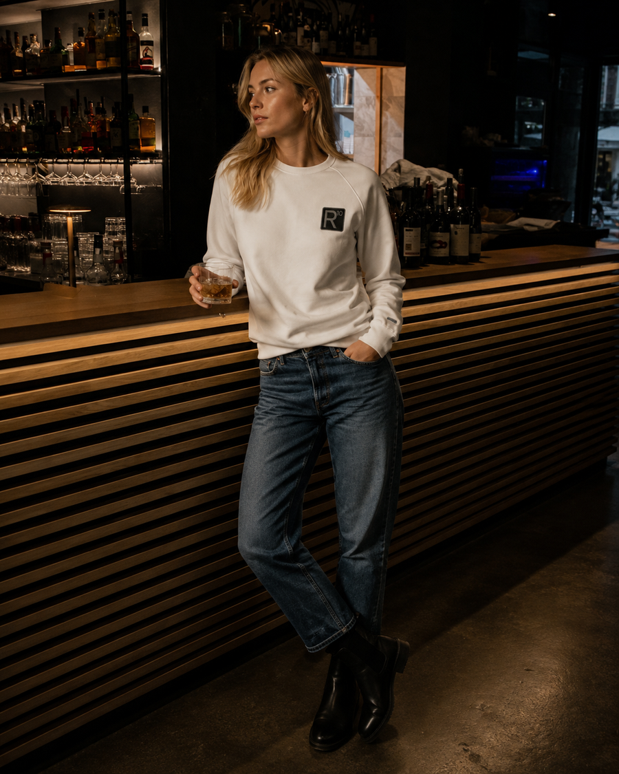 MONORETRO R10 raglan sweatshirt in off-white with embroidered R10 patch, worn at a bar.