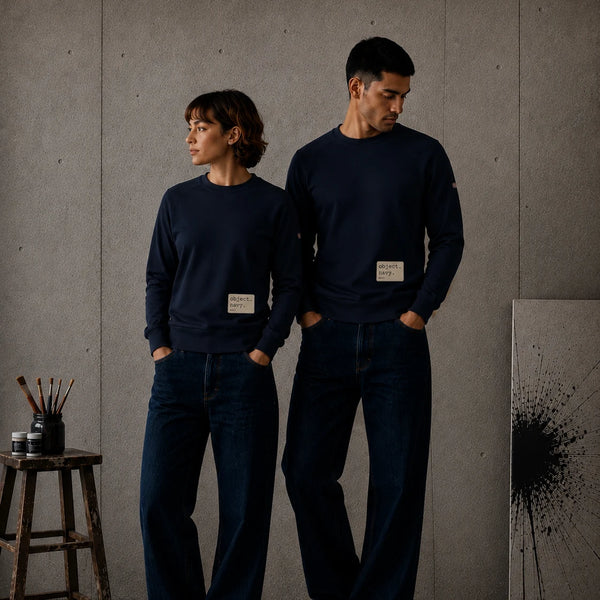 Female and male models standing against a concrete wall in navy MONORETRO object. sweatshirts.